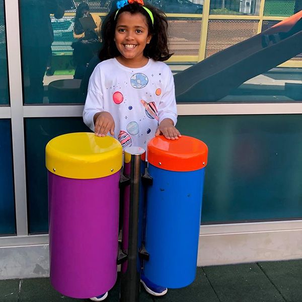 girl playing a pair of colourful conga drums at the santa maria discover museum