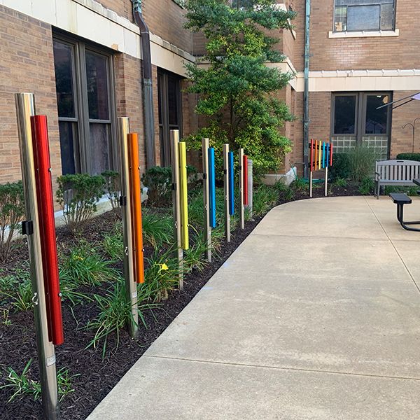 outdoor rainbow coloured chimes in a senior living facility