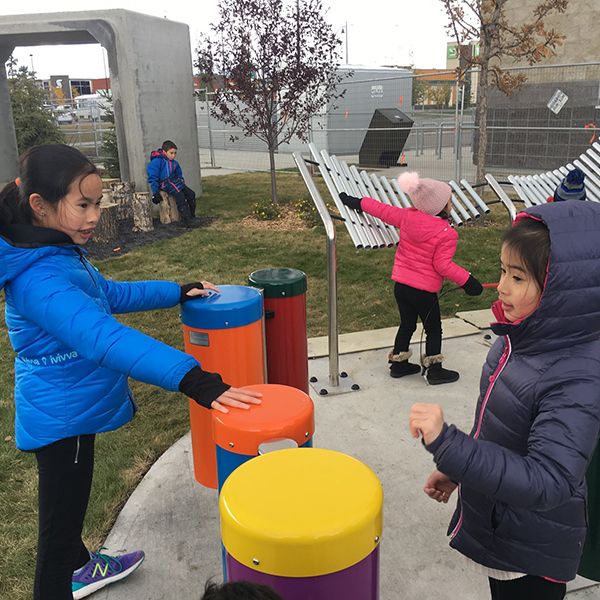 a collection of outdoor musical instruments being played in the outdoor classroom at Buffalo Rubbing Stone Elementary School in Canada