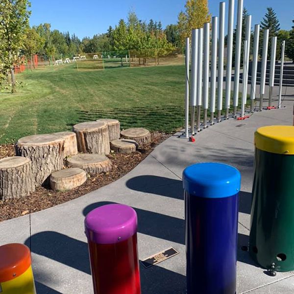 Outdoor rainbow colored drums and outdoor steel chimes in a musical playground in Calgary called the Quinterra Legacy Garden