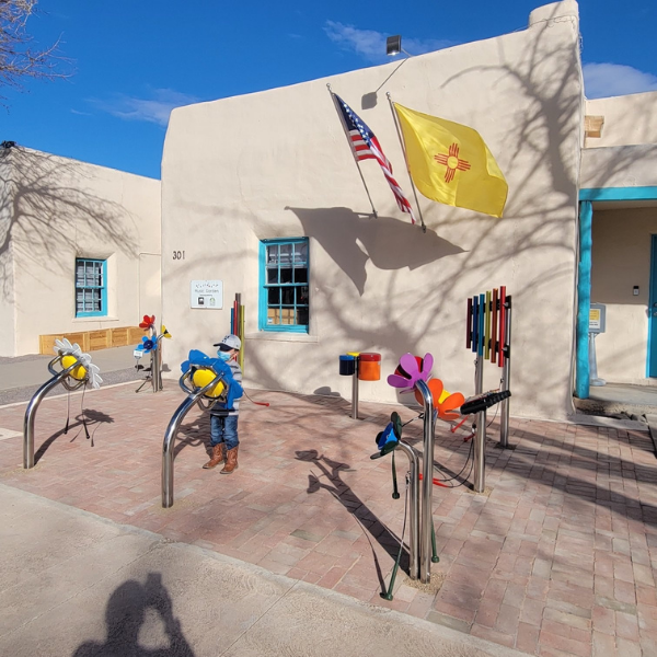 A little boy playing the outdoor musical instruments outside the Play Sharity Children's Museum