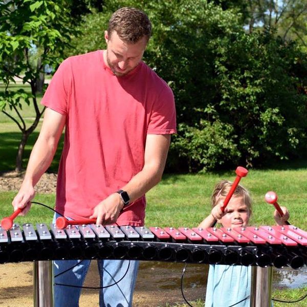 man and daughter playing a duo outdoor xylophone in st feriole memorial gardens music park