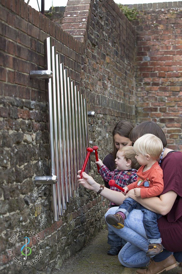 mother and child playing mirrored wall chimes together