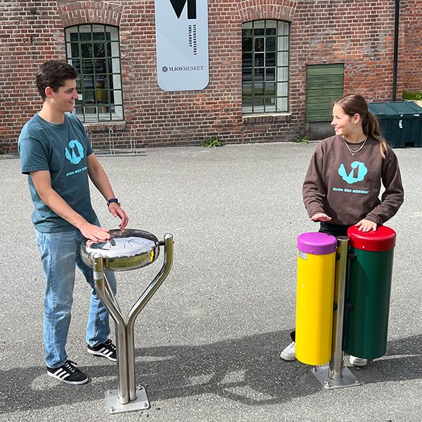  Male and female teenagers playing outdoor musical instruments outside the Vitensenteret Innlandet Science Centre in Norway