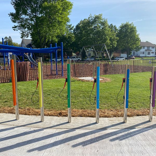 a row of outdoor musical chimes in rainbow colours