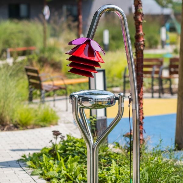 a stainless steel tongue drum and musical chimes shaped as a bell flower in a children's hospital garden