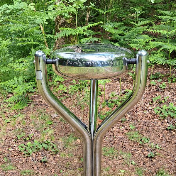 a stainless steel outdoor tongue drum called a babel drum engraved with the words Wendy's Music Garden