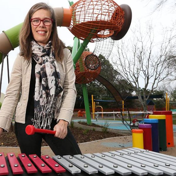 a music therapist playing on an outdoor xylophone in a new inclusive musical playground in new zealand