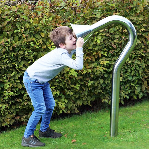 boy speaking into a large stainless steel cone playground talk tube