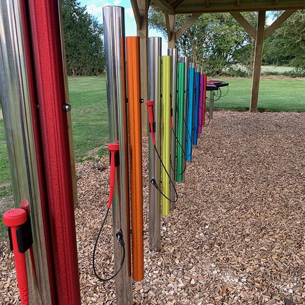 Colorful outdoor musical chimes arranged in a row at the Thomas Centre.