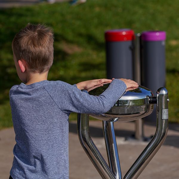 A little boy playing on the new Babel Drum in the new playground and musical play area at the Fundy Discovery Site 