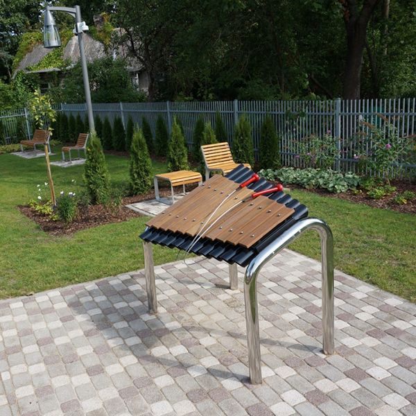 large outdoor marimba xylophone with wooden notes and stainless steel legs in a play park in latvia