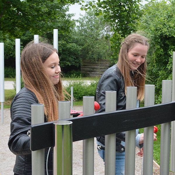 teenage girls playing musical chimes in a playground