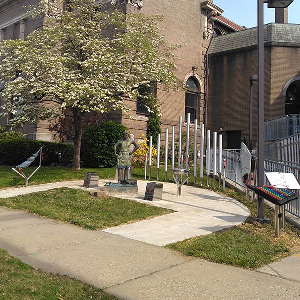 outdoor musical instruments installed next to the sidewalk outside the Oil City Library