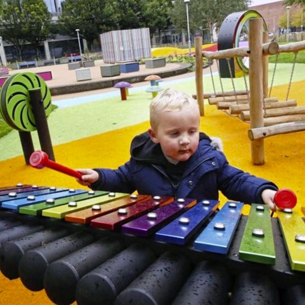 child playing the rainbow xylophone in the  inclusive music park in cathedral gardens, Belfast, Northern Ireland