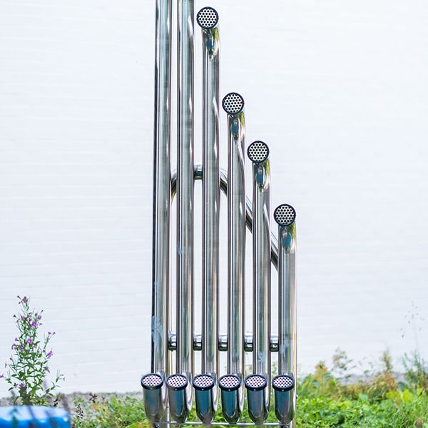 large tall stainless steel tubes with paddles in a music garden