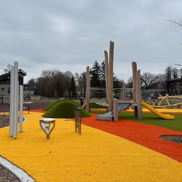 an image of outdoor musical instruments and a climbing structure in the background in a playground