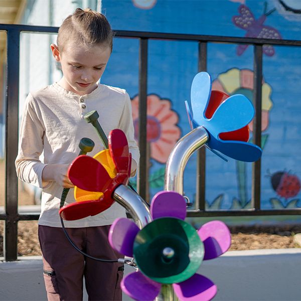 a young boy playing a set of outdoor musical flowers in McLaren PArk