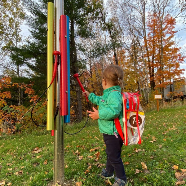 a young boy wearing a rucksack playing an outdoor musical chime in the Bethlehem Public library 