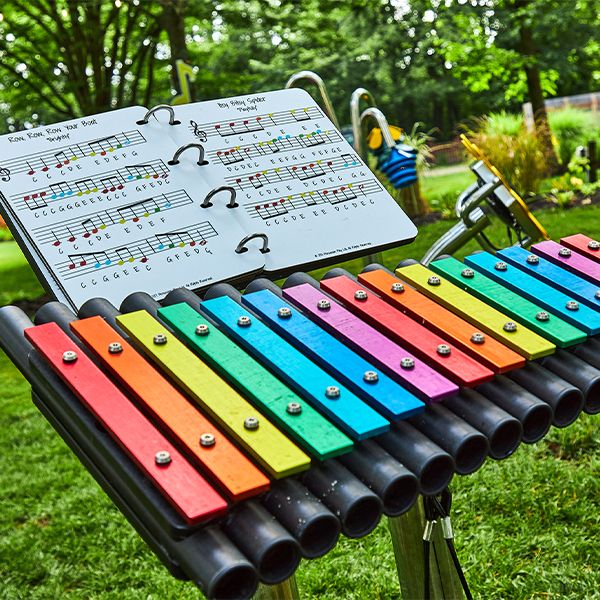 a large colorful outdoor xylophone with a music book