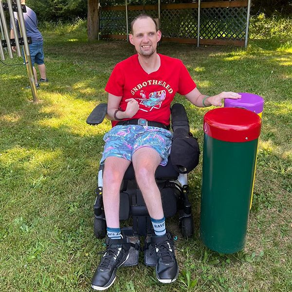 Man in a wheelchair playing outdoor conga drums in the camp beausite new musical garden