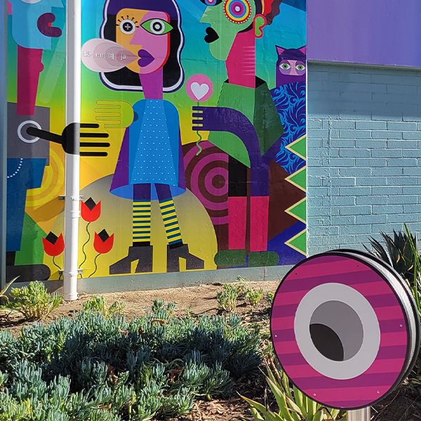 outdoor musical chimes installed in the ground and wrapped in varied colorful vinyl