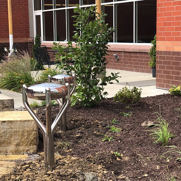 two silver Outdoor stainless steel tongue Drums in the Iowa Prison Garden 