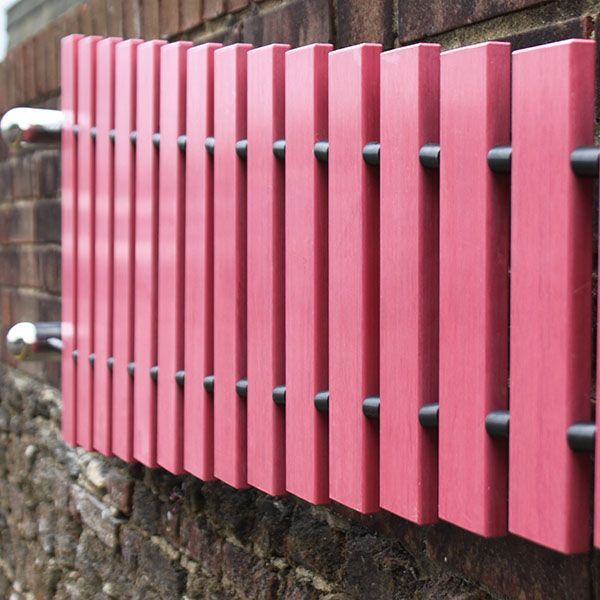 pink marimba mounted on a wall outdoors