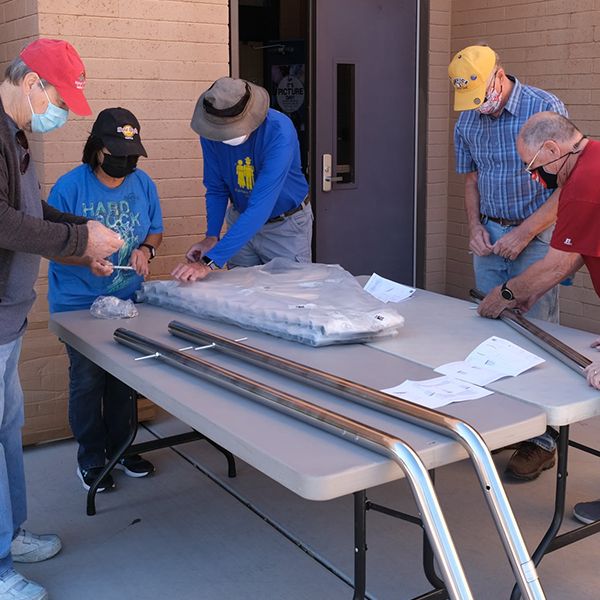 members of the Valle Verde Rotary Club unpacking outdoor musical instruments ready to install