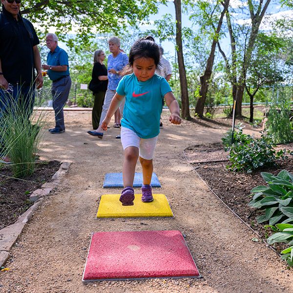 a young girl running over three musical stepping stones in a music park