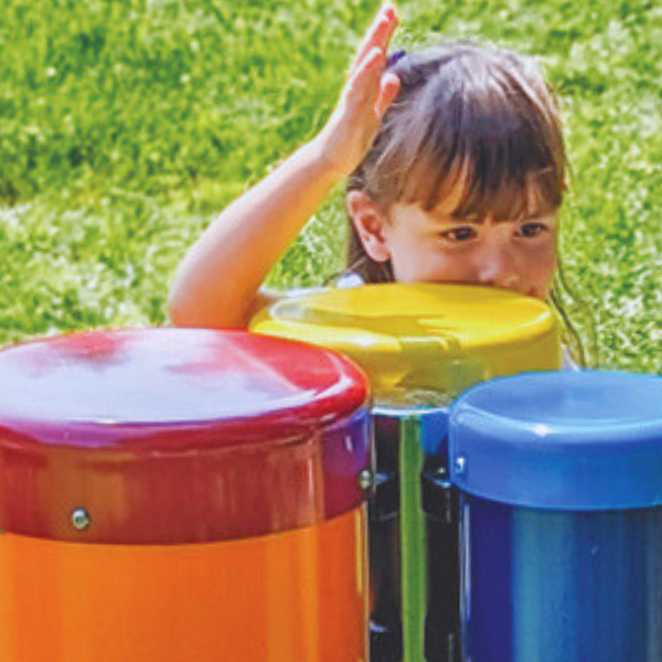 image of a young girl playing colorful bongo drums in a library garden