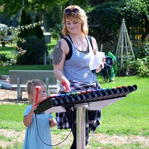 mother and child playing a small outdoor xylophone in the St Feriole Island Memorial gardens