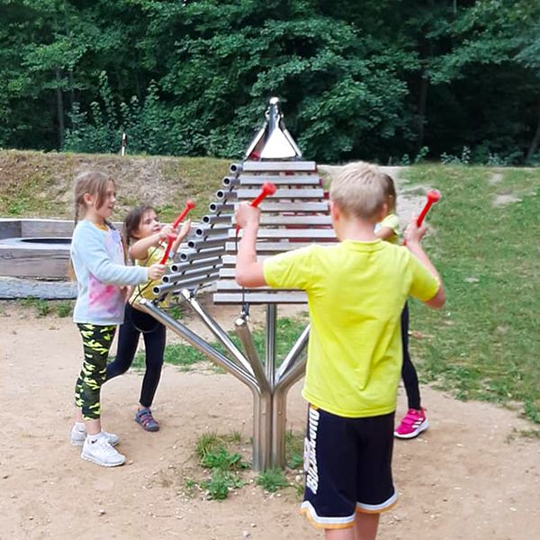 Children playing the outdoor musical instruments in the new playground at the Sirvetos Regional Park