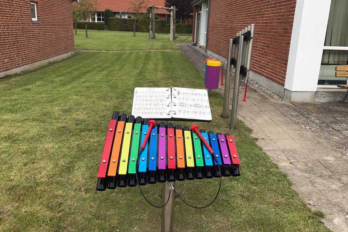 A large music book to accompany an outdoor musical instruments using a rainbow scale