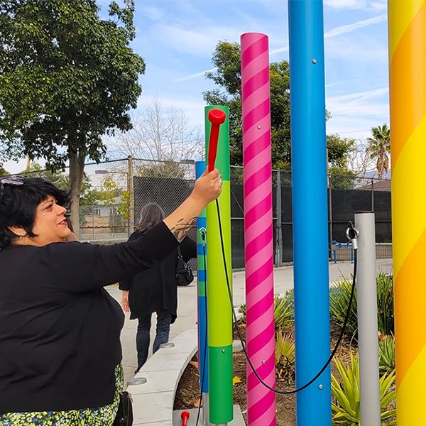 lady playing outdoor musical chimes each indivually wrapped in patterned vinyl