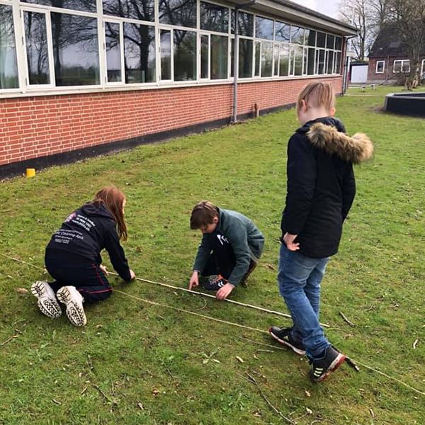 school children measuring the ground ready to install new outdoor musical instruments