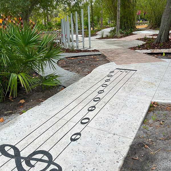 a pathway with a treble clef and musical notes  in the botanical gardens florida