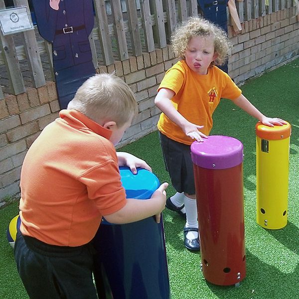 two children with special needs playing colourful outdoor playground drums