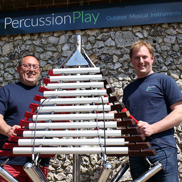 Percussion Play Directors Robin and Jody Ashfield with a large outdoor musical instrument