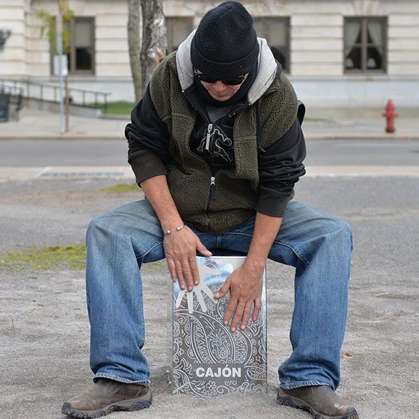 Man sat on stainless steel cajon drum in new york street