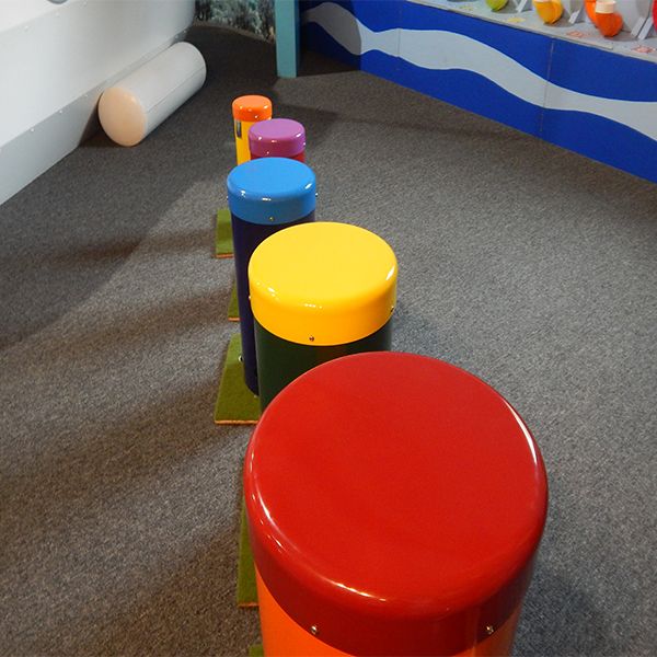 a row of rainbow coloured outdoor drums in the cape cod children's museum 