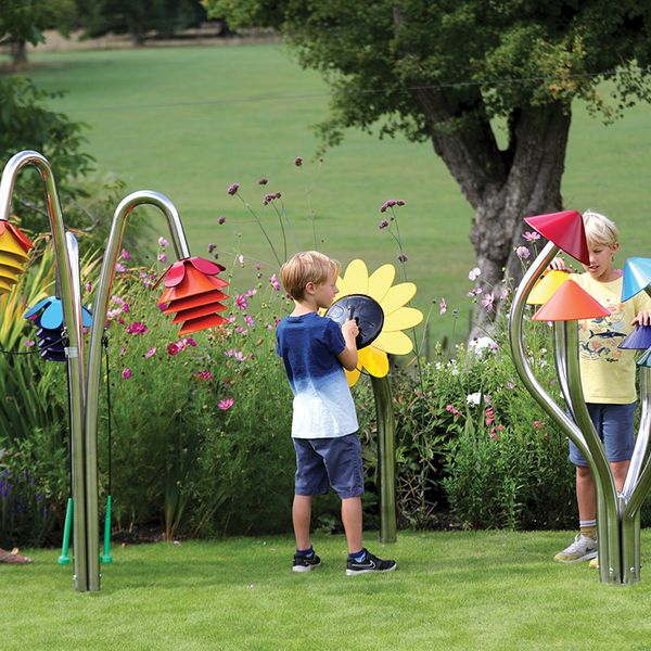 three outdoor musical instruments inspired by nature being played by a mother and two sons