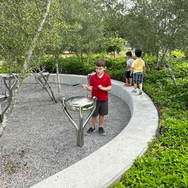 a young boy playing on a stainless steel tongue drum at the Louisiana Children's Museum