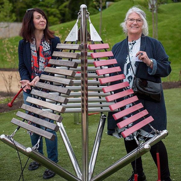 two ladies playing a large outdoor musical instrument in the playful garden in Brodie Castle National Trust Scotland 