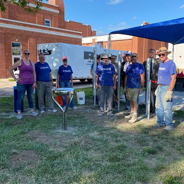 Hastings Noon Kiwanis team standing next to a recently completed outdoor musical playground in the Longfellow Elementary School Playgound