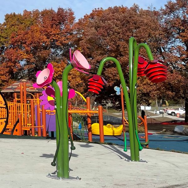 Outdoor musical instruments in a playground that are shaped as flowers with pink and red petals