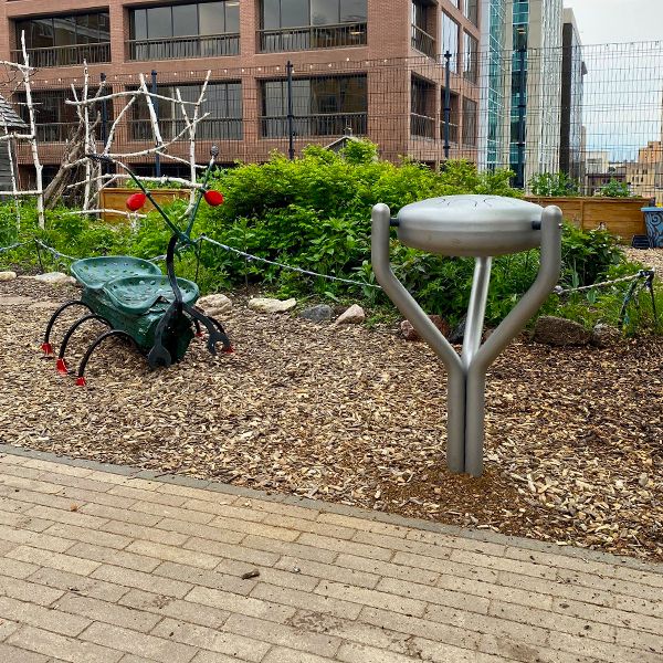 Stainless Steel Tongue Drum next to a scrap art bug on a museum rooftop garden