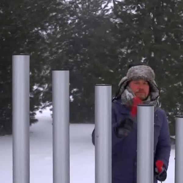 man playing on musical playground chimes in the snow