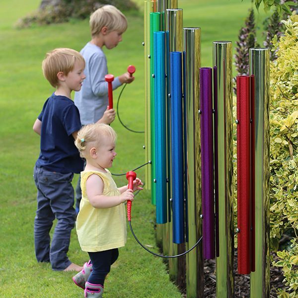 three young children playing on six rainbow colored eco chimes on individual stainless steel posts