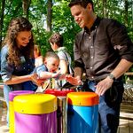 family playing the conga drums outdoor musical instruments at the Treetop Outpost at Conner Prairie History museum